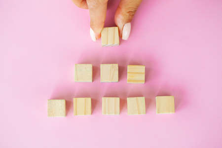 Hand putting and stacking blank wooden cubes on table with copy space for input wording and...