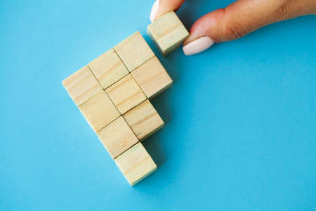 Hand putting and stacking blank wooden cubes on table with copy space for input wording and infographic icon.の写真素材