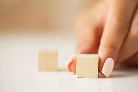 Hand putting and stacking blank wooden cubes on table with copy space for input wording and infographic icon.の写真素材