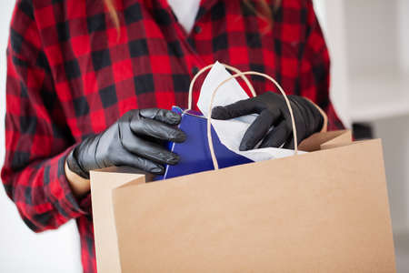 Young woman disinfects parcels before unpacking at homeの写真素材