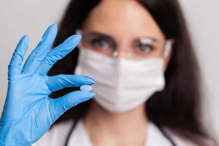 Closeup of female doctor holding pill for men healthの写真素材