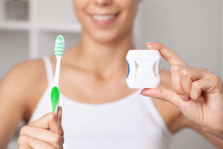 Oral hygiene and health care, smiling women use dental floss white healthy teeth.の写真素材
