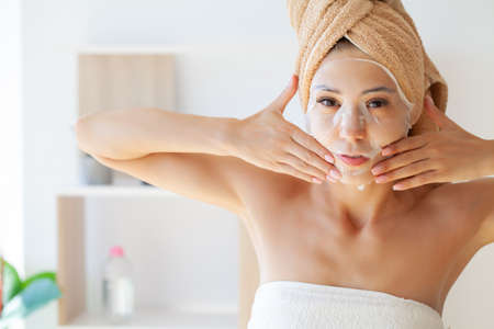 Pretty girl wearing face care mask at homeの写真素材