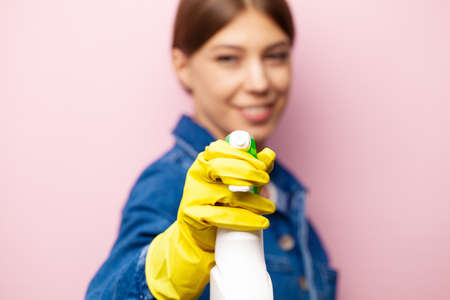 Cleaning company worker in overalls, yellow gloves and cleaning supplies