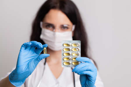 Doctor close up holding white pills for weight loss