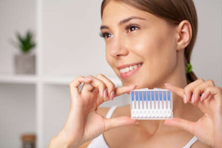 The woman uses brushes to clean the interdental spaces