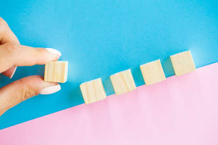 Woman hand putting and stacking blank wooden cubes on desk with copy space for input wording and...