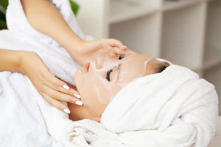 Pretty girl wearing face care mask at homeの写真素材