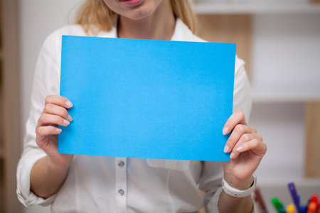 Female holding a blank sheet of paper with space for textの写真素材
