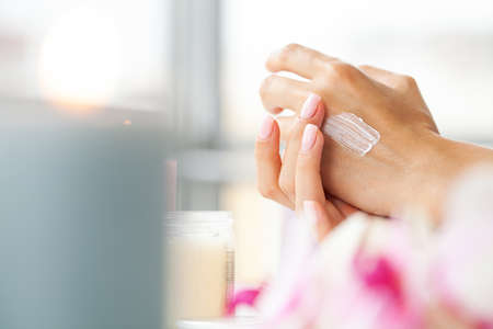 Woman applying hand cream at home, closeupの写真素材