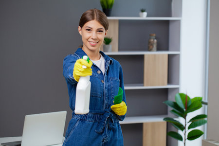 Cleaning concept, young woman with supplies cleaning office