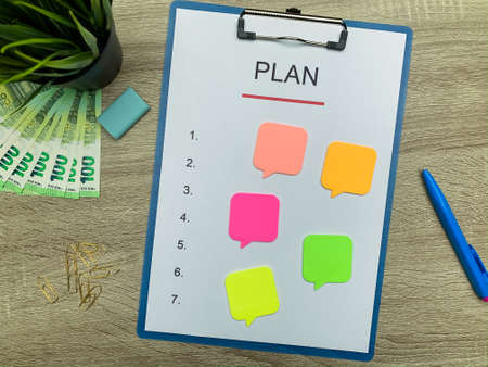 Clipboard with text plan on wood desk.の写真素材