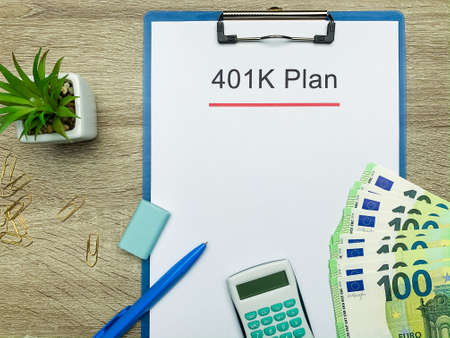 Paper with 401k plan on wood table.