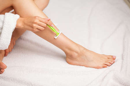 Skin care and health, fit woman shaving her legs with razor.の写真素材