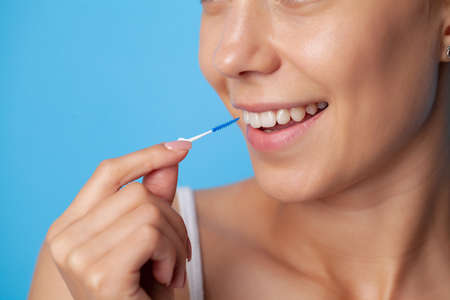 Woman uses brushes to clean the interdental spacesの写真素材