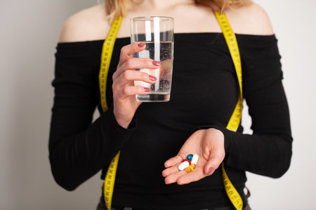 Conceptual photo of a female nutritionist holding a pill.の写真素材