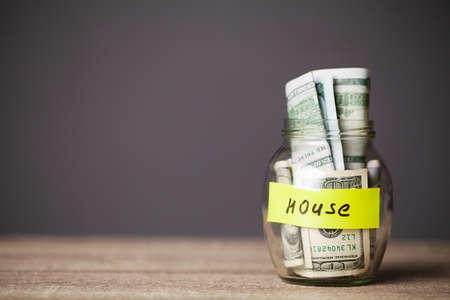 100 dollars in a glass jar with the text houseの写真素材