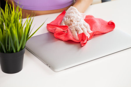 Hand of a woman wiping work desk, close-up.の写真素材