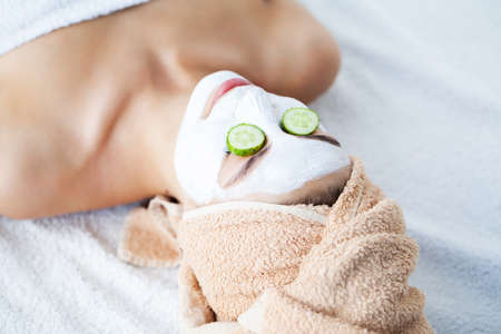 Applying white facial mask with brush at home