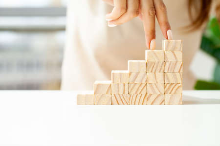 Women fingers climb up wooden block closeupの写真素材