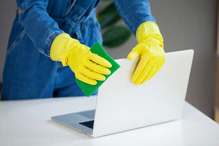 Young Worker Cleaning Desk With Rag In Office