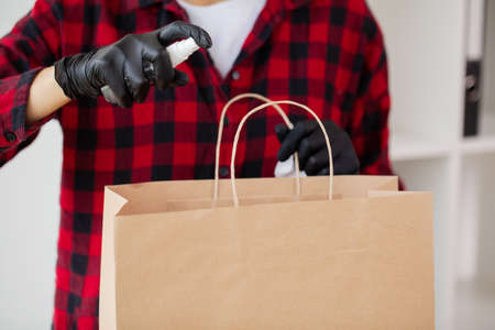 A woman wipes goods bought in a supermarket with a disinfectant wipe.