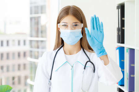 Young female nurse at camera wearing surgical maskの写真素材
