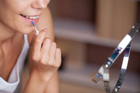 The woman uses brushes to clean the interdental spacesの写真素材