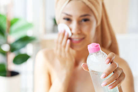 Pretty young lady doing daily morning skincare proceduresの写真素材