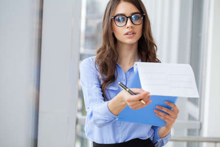 Portrait business woman in modern office looking at camera.