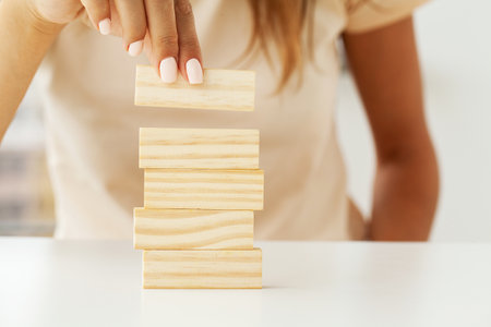 Woman hand stacked wooden blocks with space for textの写真素材
