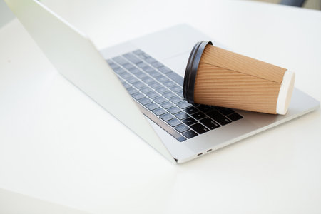 Spill coffee from paper glass on computer laptop keyboardの写真素材