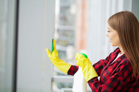 Young asian woman washing window with sponge.の写真素材