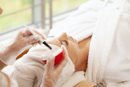 Woman getting facial care by beautician at spa salonの写真素材