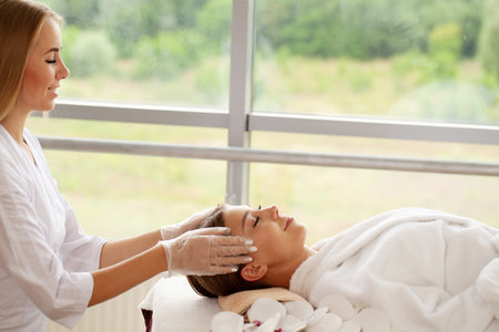 Close-up of young woman getting spa massage treatment at beauty spa salonの写真素材