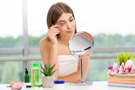 Portrait beautiful woman doing makeup in front of mirror.の写真素材