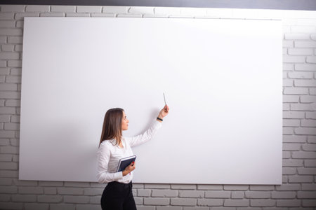Smiling girl student or woman teacher portrait on white wallの写真素材