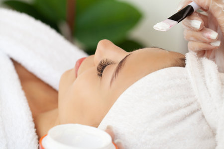 Beautiful african woman getting face massage in beauty spa.の写真素材