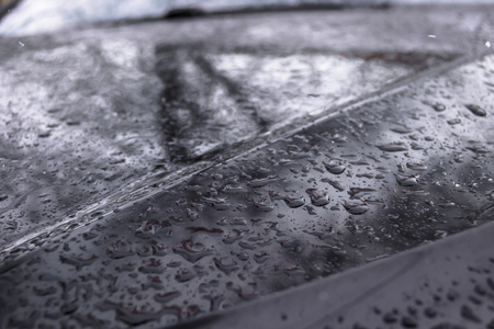 Drops of the water after the rains on the carpaint with blurred backgroundの写真素材