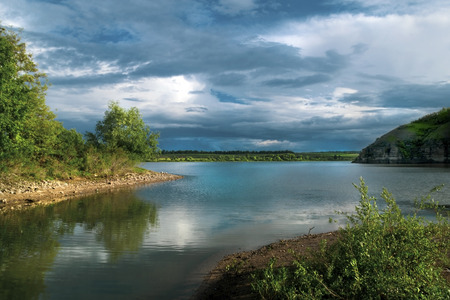 Beautiful river landscape. Calm river with colorful sky reflection on it. River flow on sunsetの写真素材