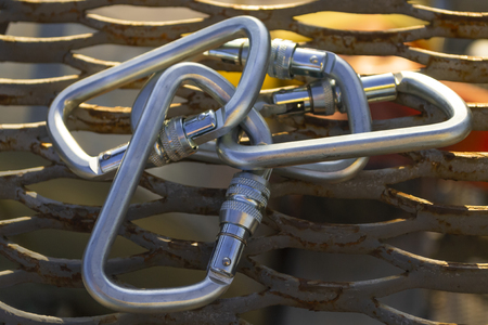 Several steel carabiners on rust expanded metal mesh. Industrial. Alpinism. Rope climbingの写真素材