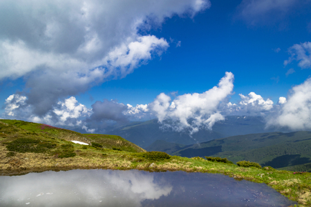 Clear Alpine lake with reflection of blue cloudy skyの写真素材