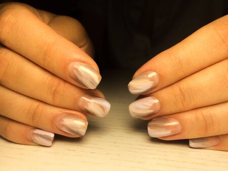 Nails care. Woman hands with  manicure on dark background. Closeup photo. Healthcare. Spaの写真素材