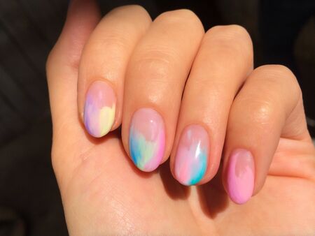 Woman hands with manicure on dark background. Closeup photoの写真素材