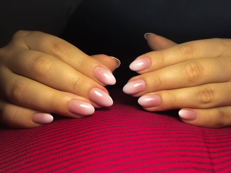 Nails care. Woman hands with manicure on a pink fabric background. Closeup photo.. Healthcare, Beautyの写真素材