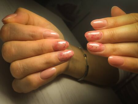 Woman hands with manicure on table. Closeup photo. Delicate colorsの写真素材