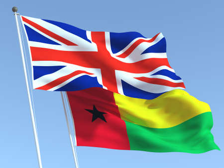 Two waving state flags of United Kingdom and Guinea Bissau on the blue sky. High - quality business background. 3d illustrationの写真素材