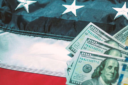 American dollars banknotes on the flag of United States of America. US dollars background. 100 USDの写真素材