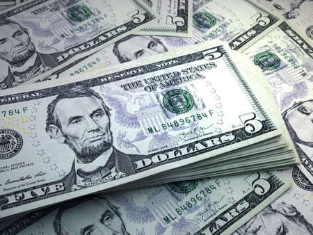 Money of United States. United States dollar bills. USD banknotes. 5 dollars. Business, finance, news background.の写真素材