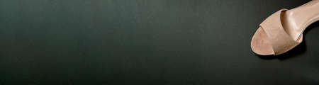 women's shoes of beige color on a black background. shoes removed from the top. shoes are at an...